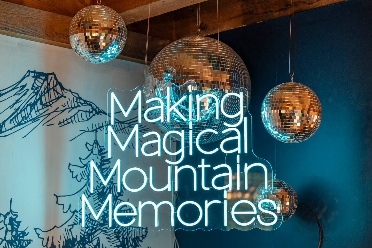 Game room with neon 'Making Magical Mountain Memories' sign